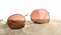 Stylish sunglasses on sand against white background. Space for text Royalty Free Stock Photo