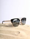Stylish sunglasses on sand against white background. Space for text Royalty Free Stock Photo