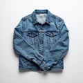 Folded Denim Jacket on Matte White Background with Sleeve Visible Royalty Free Stock Photo