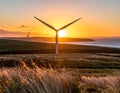 The sun is setting behind the wind turbine, Royalty Free Stock Photo