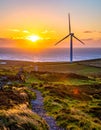 The sun is setting behind the wind turbine, Royalty Free Stock Photo