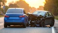 The scene of the car crash where a blue vehicle hit a black car on the road Royalty Free Stock Photo