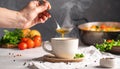 Close-up ladling steaming veggie soup into cup in cozy home kitchen Royalty Free Stock Photo
