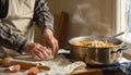 Warm winter home scene with dough kneading next to steaming pot Royalty Free Stock Photo
