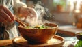 Hands stirring hot miso soup in wooden bowl with rising steam, cozy kitchen Royalty Free Stock Photo
