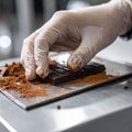 Close-up of chocolate bar slicing on stainless food processing table Royalty Free Stock Photo