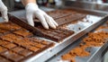 Close-up of chocolate bar slicing on stainless food processing table Royalty Free Stock Photo