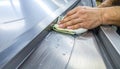 Close-up of worker cleaning polished metal conveyor with sanitizer cloth Royalty Free Stock Photo