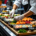 Gloved hands arranging sushi ingredients in trays in clean industrial kitchen Royalty Free Stock Photo