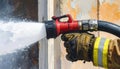 Firefighter's Hand Sprays Water from Hose Royalty Free Stock Photo