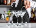 Barman pouring cold martini into glasses on counter, closeup Royalty Free Stock Photo