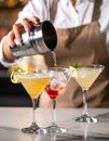 Barman pouring cold martini into glasses on counter, closeup Royalty Free Stock Photo