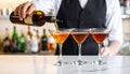 Barman pouring cold martini into glasses on counter, closeup Royalty Free Stock Photo