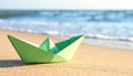 Light green paper boat near sea on sandy beach, space for text Royalty Free Stock Photo