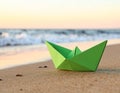 Light green paper boat near sea on sandy beach, space for text Royalty Free Stock Photo