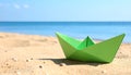 Light green paper boat near sea on sandy beach, space for text Royalty Free Stock Photo