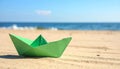 Light green paper boat near sea on sandy beach, space for text Royalty Free Stock Photo