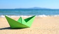 Light green paper boat near sea on sandy beach, space for text Royalty Free Stock Photo