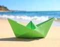 Light green paper boat near sea on sandy beach, space for text Royalty Free Stock Photo