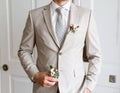 Inside, the groom in a suit with a stylish boutonniere was standing in front of a closeup Royalty Free Stock Photo