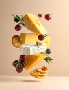 Different types of cheese, crackers, grapes, rosemary and walnuts in air on dark beig Royalty Free Stock Photo