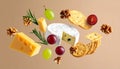 Different types of cheese, crackers, grapes, rosemary and walnuts in air on dark beig Royalty Free Stock Photo