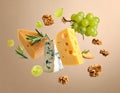 Different types of cheese, crackers, grapes, rosemary and walnuts in air on dark beig Royalty Free Stock Photo
