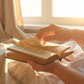 Hands Turning Book Pages by Window in Warm Light Royalty Free Stock Photo
