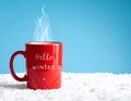 Red mug with words Hello winter on the blue background. Royalty Free Stock Photo