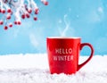Red mug with words Hello winter on the blue background. Royalty Free Stock Photo