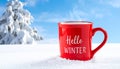 Red mug with words Hello winter on the blue background. Royalty Free Stock Photo