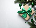 Christmas gift box with green bow and festive decor on light table, flat lay. Royalty Free Stock Photo