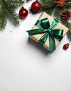 Christmas gift box with green bow and festive decor on light table, flat lay. Royalty Free Stock Photo