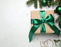 Christmas gift box with green bow and festive decor on light table, flat lay. Royalty Free Stock Photo