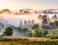 The beautiful view of the houses and trees covered in morning mist. Royalty Free Stock Photo