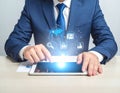 Digital marketing. A businessman using a tablet computer at the table. Symbols coming Royalty Free Stock Photo