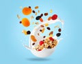 Milk splashes with oats and dried fruits floating in the air on a light blue background Royalty Free Stock Photo