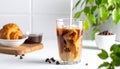 Pouring milk into a glass of iced coffee on a white table, closing Royalty Free Stock Photo