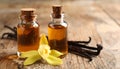 Aromatic vanilla extract, pods and flower on wooden table, closeup Royalty Free Stock Photo