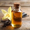 Aromatic vanilla extract, pods and flower on wooden table, closeup Royalty Free Stock Photo