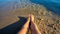 Bare Feet on Sandy Beach with Clear Water and Sunlight Reflections Royalty Free Stock Photo