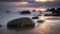 Serene Beach Sunrise with Smooth Stones and Silky Water Royalty Free Stock Photo