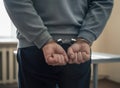 Man in handcuffs, hands behind back in interrogation room Royalty Free Stock Photo