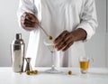 The woman is preparing an olive martini cocktail on a small table. Royalty Free Stock Photo