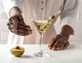 The woman is preparing an olive martini cocktail on a small table. Royalty Free Stock Photo