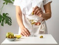 The woman is preparing an olive martini cocktail on a small table. Royalty Free Stock Photo