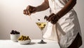 The woman is preparing an olive martini cocktail on a small table. Royalty Free Stock Photo