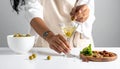 The woman is preparing an olive martini cocktail on a small table. Royalty Free Stock Photo