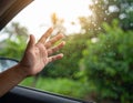 A close-up of a hand reaching out from a car window, with raindrops on the glass. Royalty Free Stock Photo