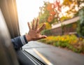A close-up of a hand reaching out from a car window, with raindrops on the glass. Royalty Free Stock Photo